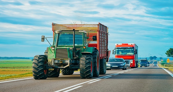 Un tracteur sur la route avec des véhicules