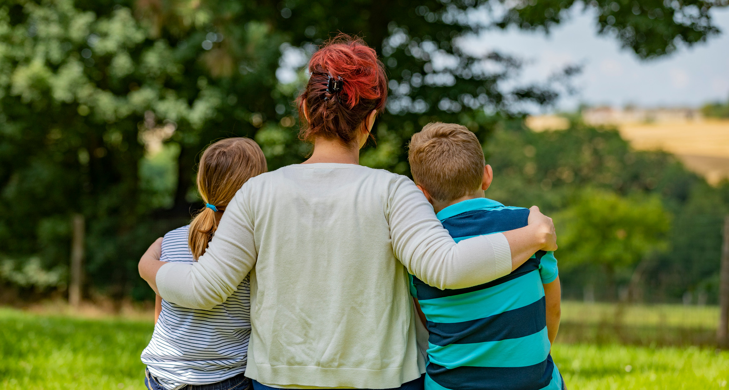 Une mère prenant son fils et sa fille par les épaules